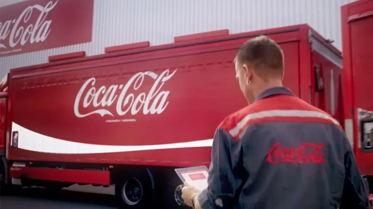 Logo Coca-Cola illustrant les profits records et suppressions d'emplois.